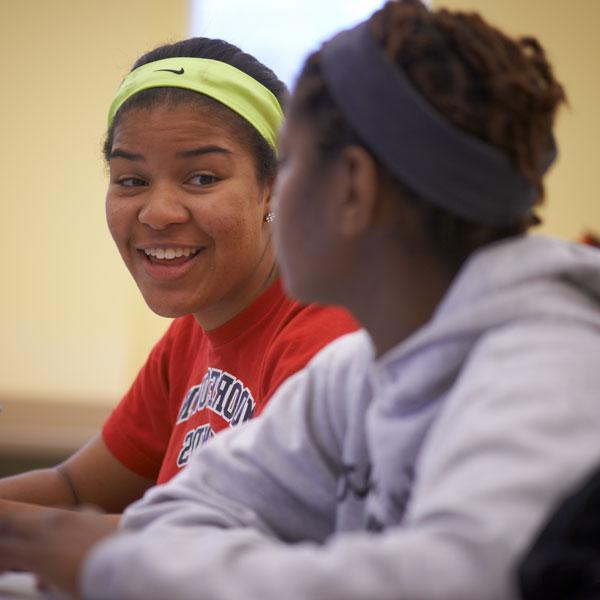 Two students smiling at each other.